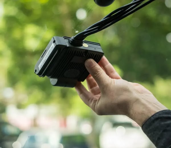 Driver installing a Transpoco device onto his windscreen