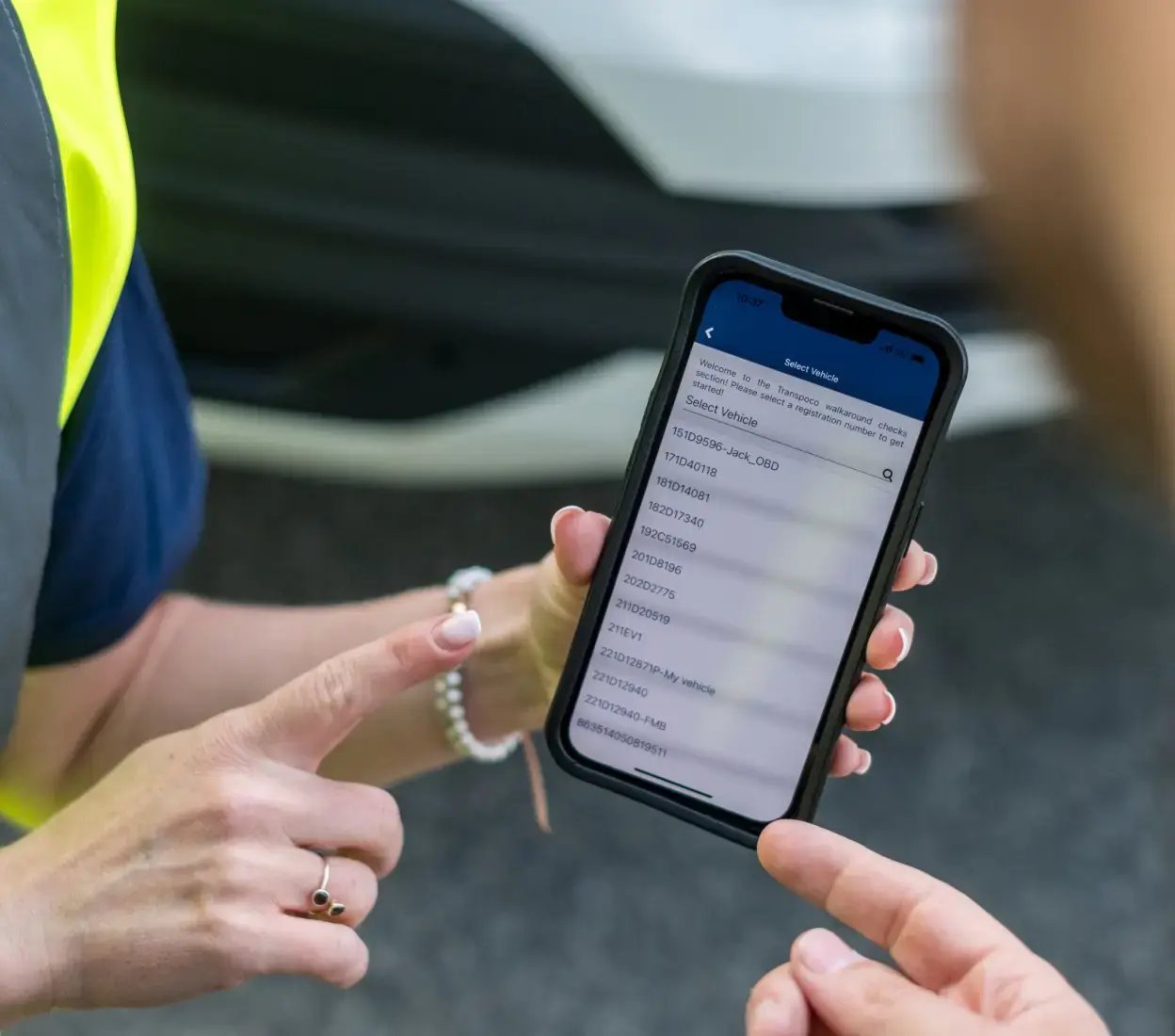 Transpoco employees reviewing vehicle telematics data on a smartphone