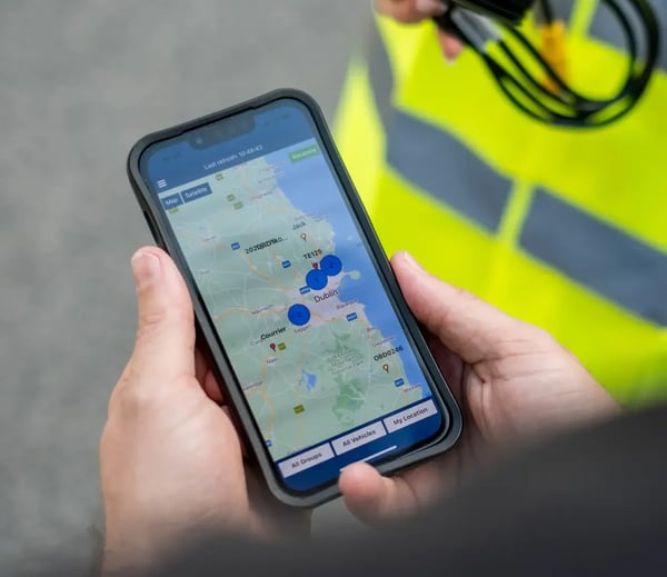 Person looking at vehicle tracking data on a smartphone