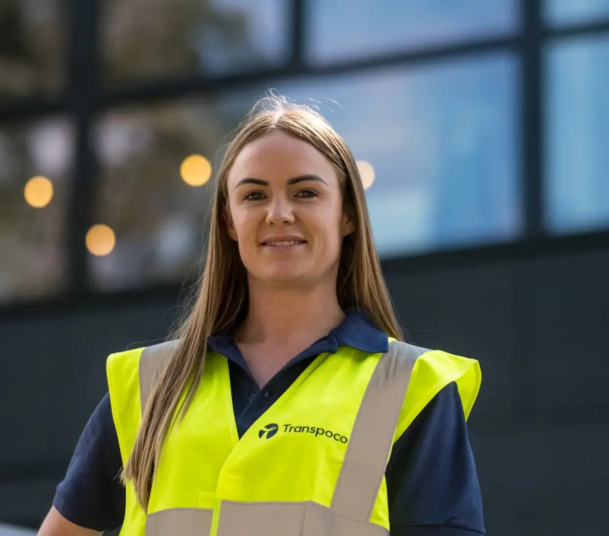 Transpoco employee wearing a hi-vis jacket over a blue shirt