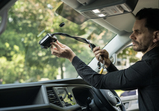 Driver installing fleet telematics software on his van windscreen